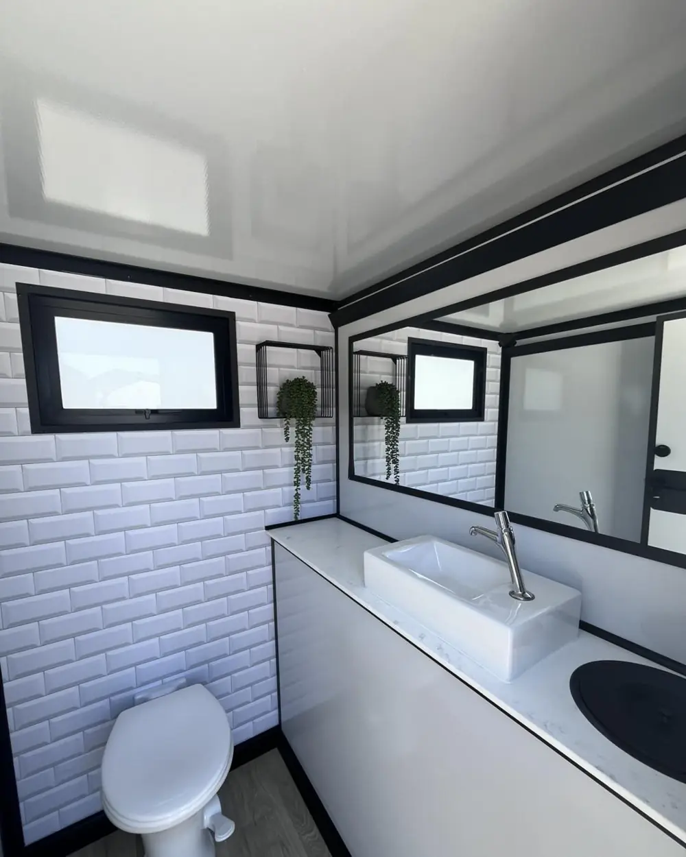 Restroom trailer room with tile walls, sink and mirror
