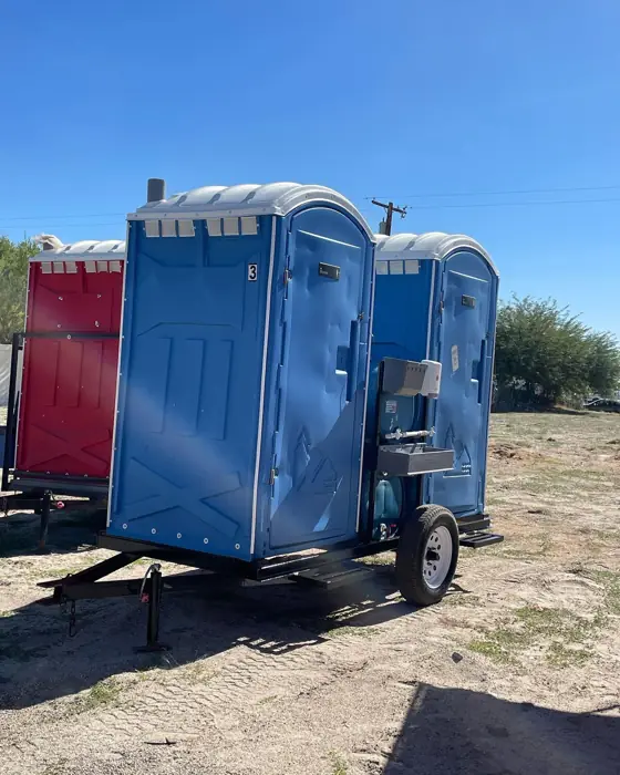 Trailer-mounted porta potties on a dirt job site