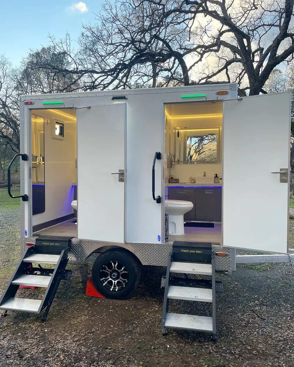 Two-station restroom trailer with steps up to each door